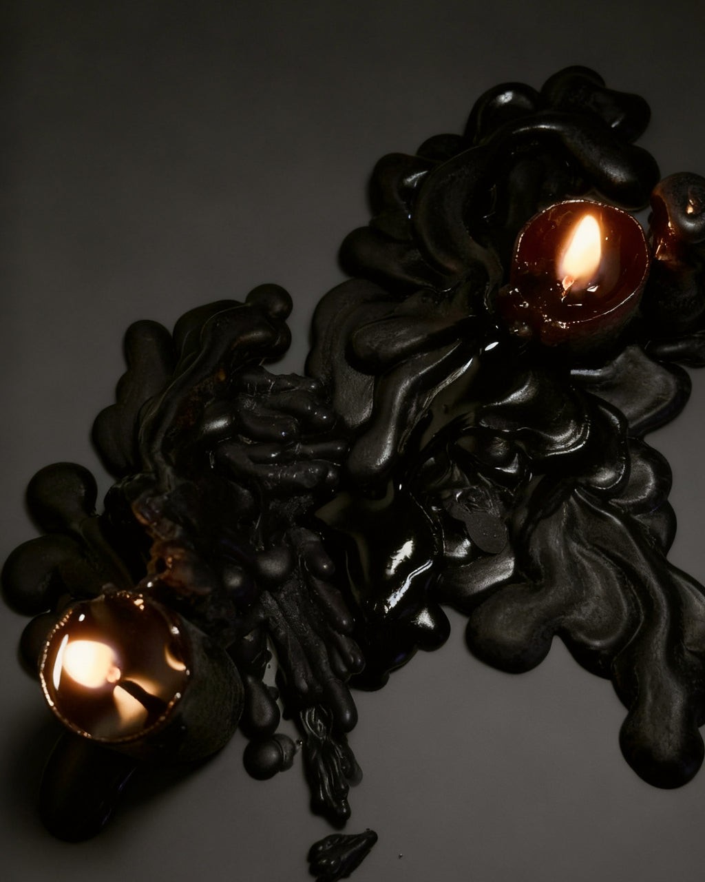 Black candles wax melted on black background 