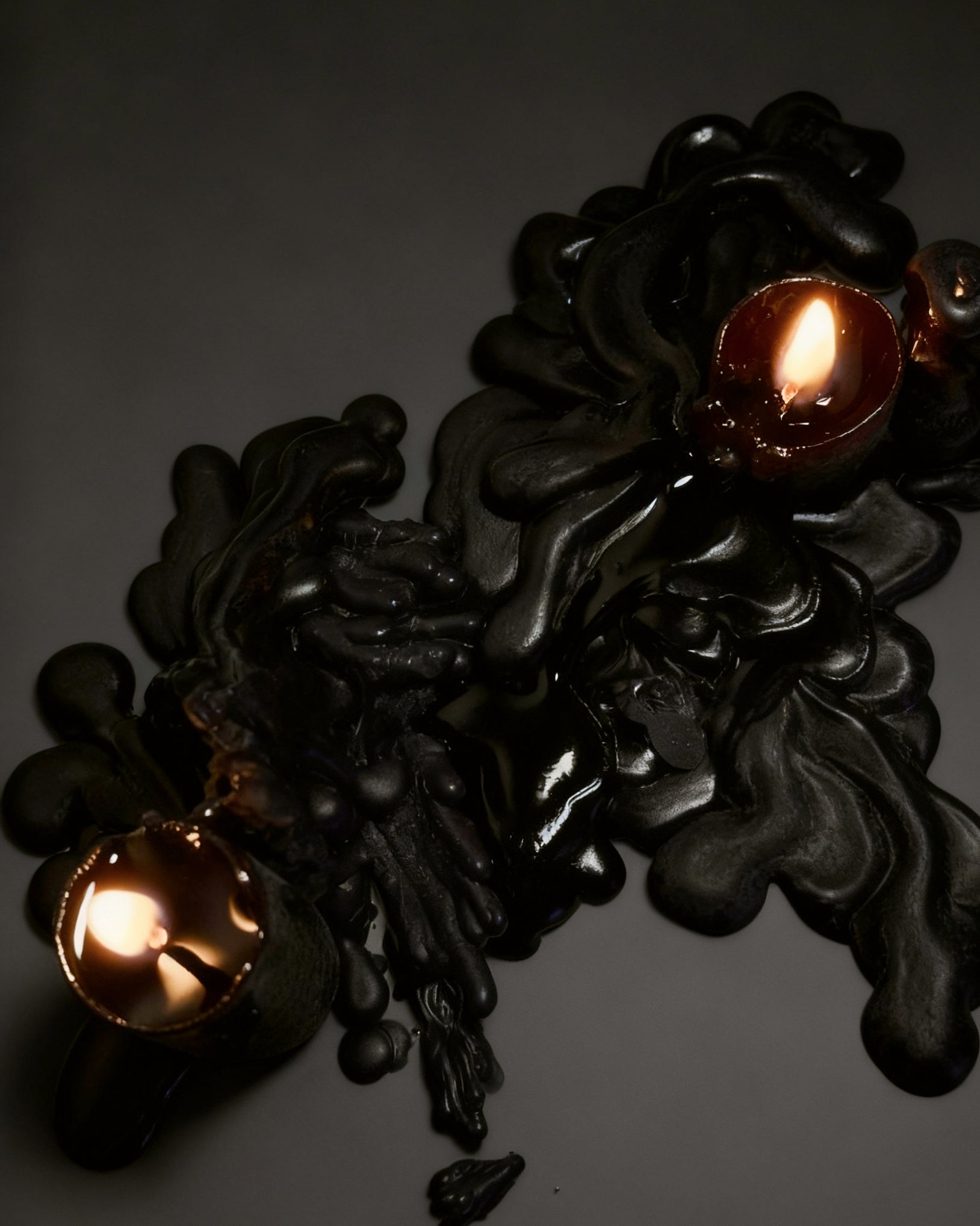 Black candles wax melted on black background 